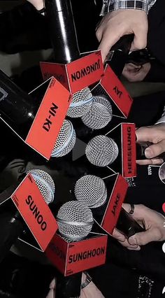 several people are holding microphones with red labels on them