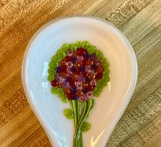 a white heart shaped dish with flowers on it