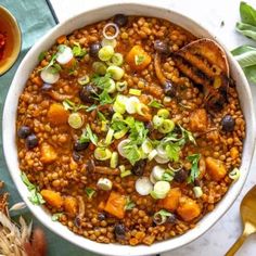 a white bowl filled with beans and vegetables next to other foods on top of a table