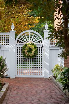 a white gate with a wreath hanging on it