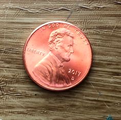 a penny sitting on top of a wooden table