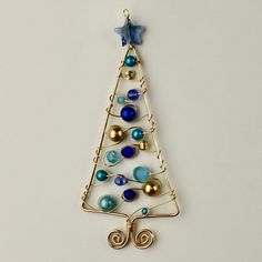 a christmas tree ornament with blue and gold balls hanging from it's side