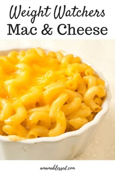 a white bowl filled with macaroni and cheese on top of a table next to a