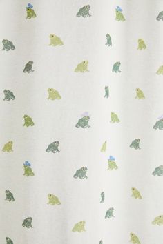 a white shower curtain with green and blue animals on it