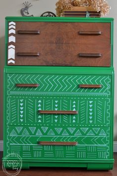 an old dresser painted green with geometric designs