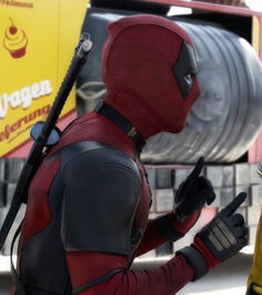 two people dressed as deadpools standing next to each other in front of a truck