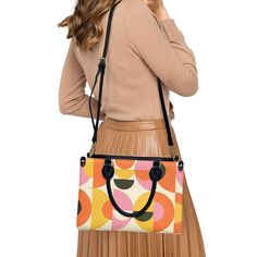 • Elevate your style with our retro style 60s Space Age Opt Art Handbag, a chic fusion of mod and vintage aesthetics inspired by the iconic designs of the 60s.• This Mod 60s Handbag features a mesmerizing geometric opt art pattern print in vibrant shades of orange, pink, yellow, and black, adding a bold and artistic touch to any outfit.• Crafted from premium PU leather, this Retro Handbag Women boasts an exquisite zipper closure and comes with a removable strap for added versatility.• Available in three sizes - small, medium, and large - and with two handle options in black and white, this 60s Style Handbag offers both style and practicality for every occasion.**Designed in California by Trendy Hip Buys. Made to order from overseas.