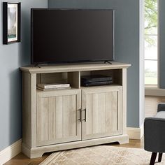 a flat screen tv sitting on top of a wooden cabinet in front of a blue wall