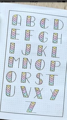 the alphabet is drawn on top of a piece of paper with markers and pencils next to it