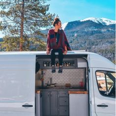 a woman sitting on the roof of a van