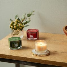 three candles sitting on top of a wooden table