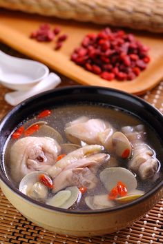 a bowl of soup with meat and vegetables on the table next to chopsticks