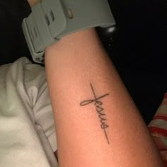 a person with a cross tattoo on their arm