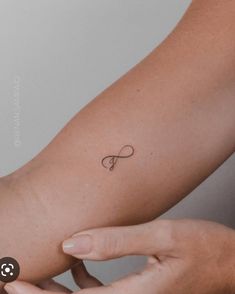 a woman's arm with a small tattoo on the left side of her arm