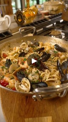 a pan filled with pasta and clams on top of a stove