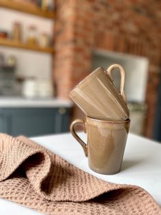 a coffee cup and saucer sitting on top of a table next to a towel