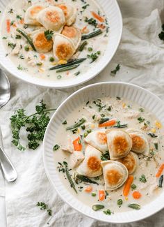 two bowls of soup with dumplings and vegetables