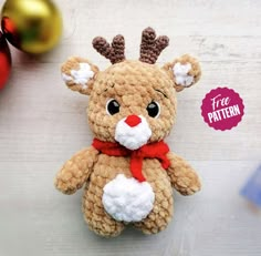 a crocheted reindeer stuffed animal sitting next to christmas ornaments