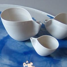 three white bowls on a blue and white plate