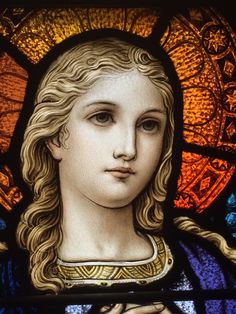 a close up of a stained glass window with a woman's face