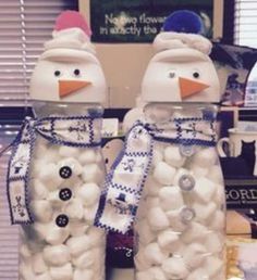 two snowmen made out of marshmallows sitting on top of a desk