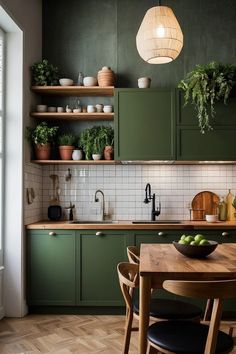 a kitchen with green cabinets and wooden table in front of the counter top, surrounded by potted plants