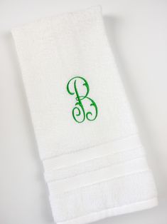 the monogrammed towel is white with green trim and has a letter b on it