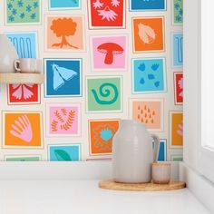 the wallpaper in this kitchen is colorful and has many different designs on it, including handprints