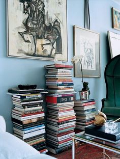 a living room filled with lots of books on top of a table next to a couch