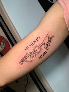 a tattoo that says mementoo and two hands holding each other