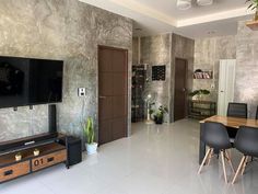 a living room filled with furniture and a flat screen tv on top of a wooden table