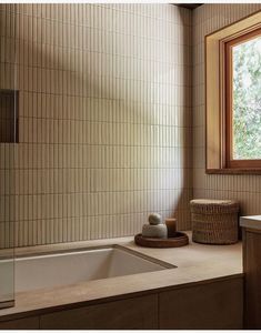 a bath room with a sink and a tub next to a window in the corner