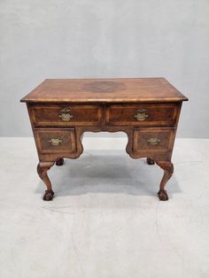 an old wooden desk with two drawers on one side and gold knobs on the other