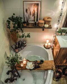 a bathtub with candles and plants in it