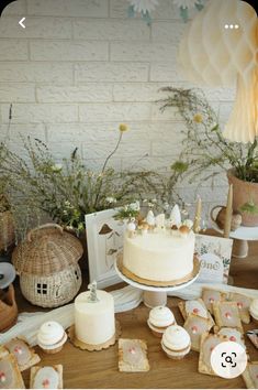 a table topped with a white cake and lots of cupcakes