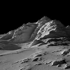 a mountain covered in snow under a dark sky with no one on it's side