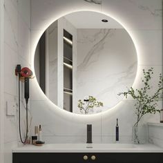 a bathroom sink with a round mirror on the wall above it and a black cabinet underneath