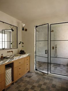 a bathroom with two sinks, mirrors and a walk - in shower stall is shown