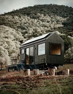 a tiny house sitting on top of a lush green hillside