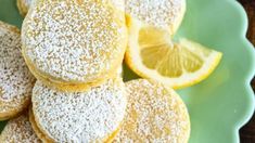 powdered sugar covered lemon cookies on a green plate