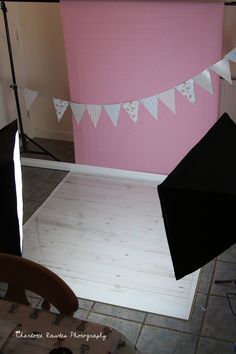 an empty room with two black umbrellas on the floor and some white bunting