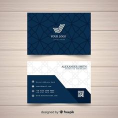 two business cards with blue and white patterns on wood background, one is for an interior designer