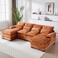 a living room with a large sectional couch and white rug on the floor in front of a window