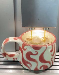 a coffee cup with two candles in it