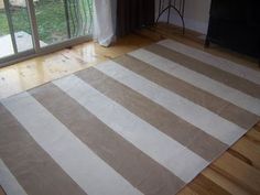 a living room with a large striped rug on the floor and sliding glass doors leading outside