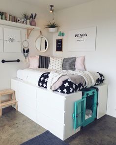 a bed with pillows and blankets on top of it next to a wall mounted shelf