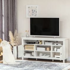 a flat screen tv sitting on top of a white entertainment center in a living room