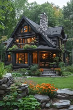 a log home with stone steps leading up to the front door and windows, surrounded by lush greenery