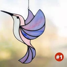 a stained glass hummingbird hanging from a chain with the number 1 on it's side