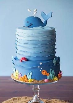 there is a blue cake with a whale on the top and other decorations around it